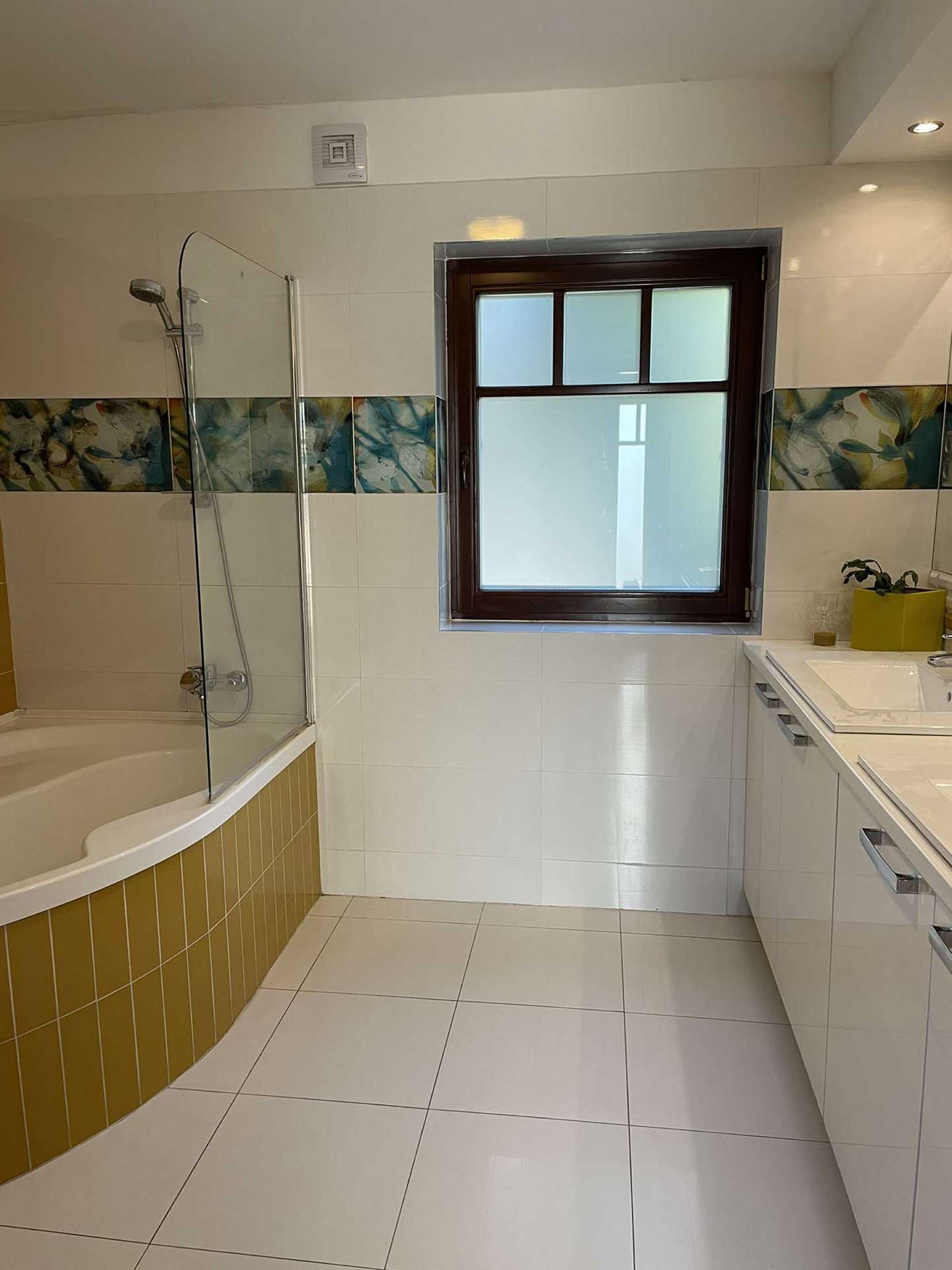 A képen, az eladó balatoni lakóház fürdőszobája látszik a dupla mosdóval és a káddal.